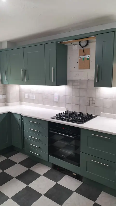 Dark green shaker kitchen with a chequered floor