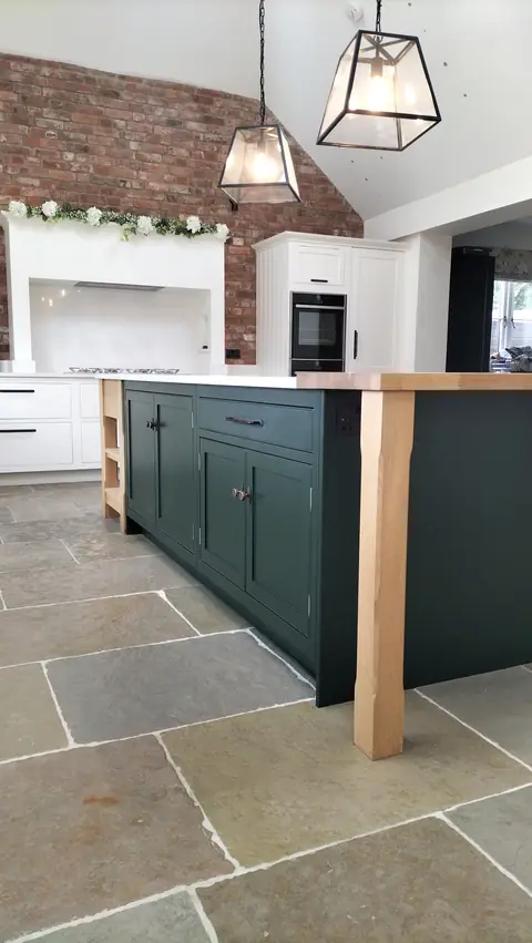 Dark green island with an oak post under pendant lanterns