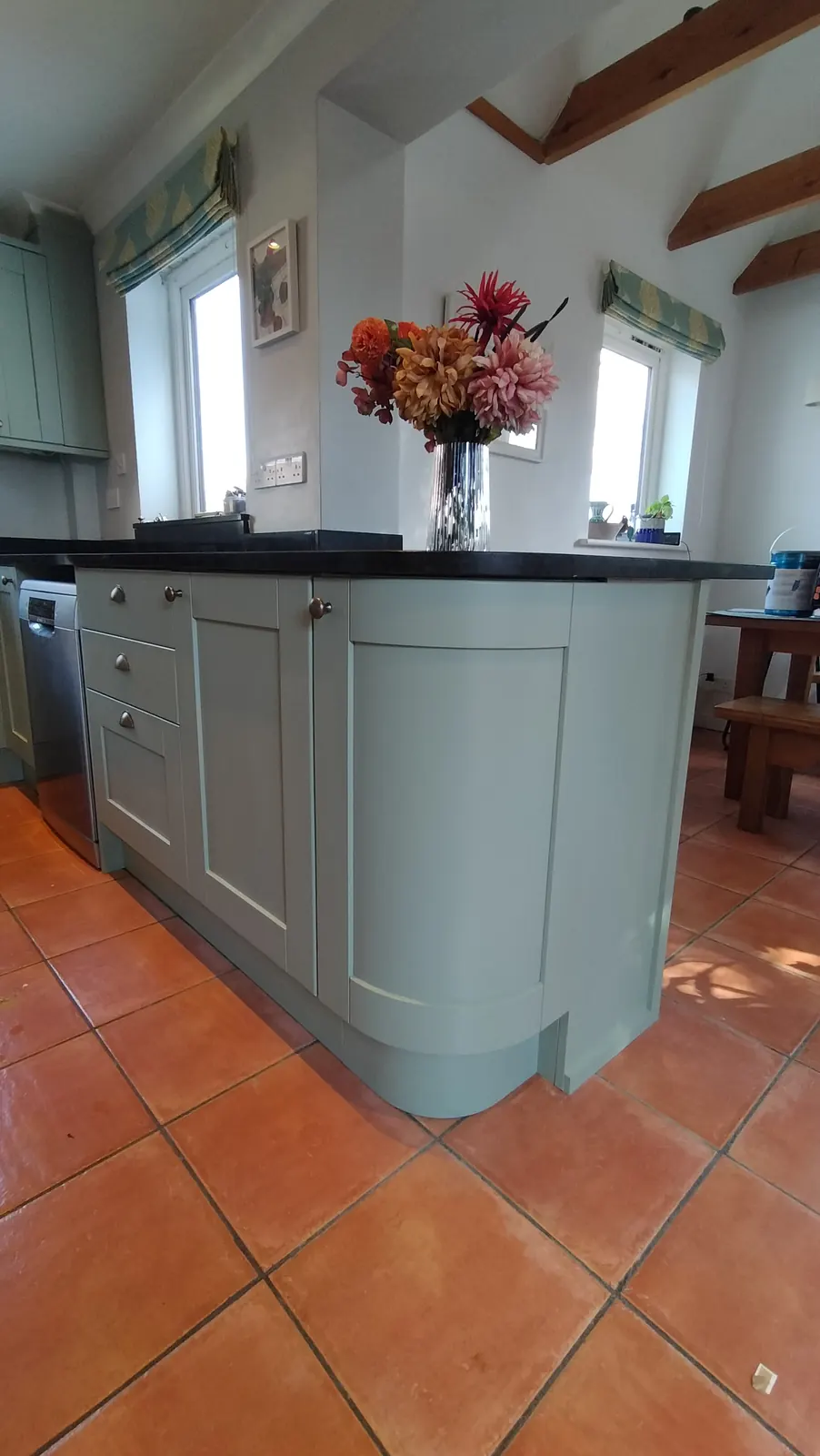 Sage green curved kitchen island on terracotta tiles, resprayed in Hampshire