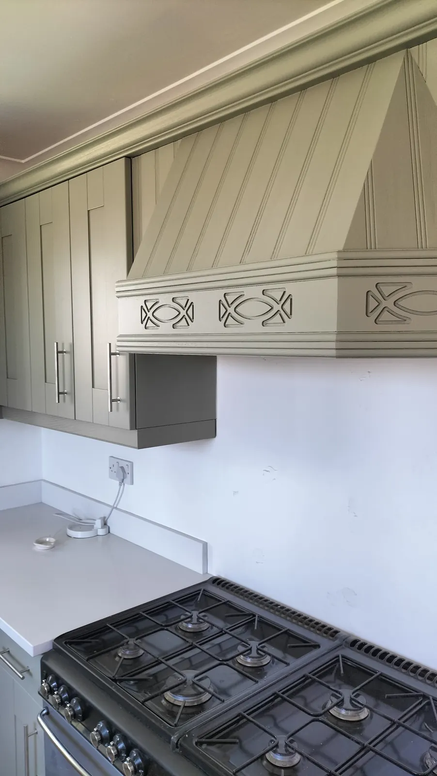 Grey-green shaker kitchen with a panelled cooker hood, professionally resprayed in Hampshire