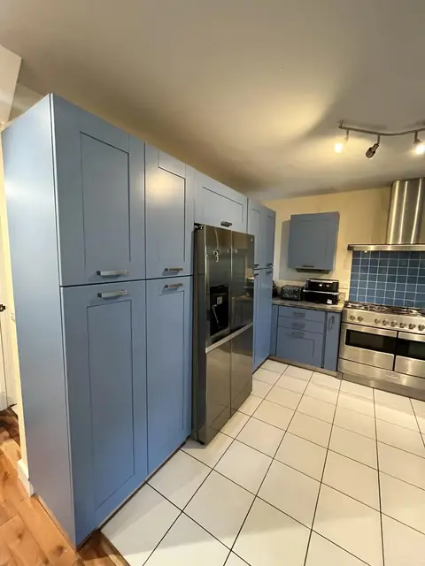 Blue-grey tall units around an American fridge freezer